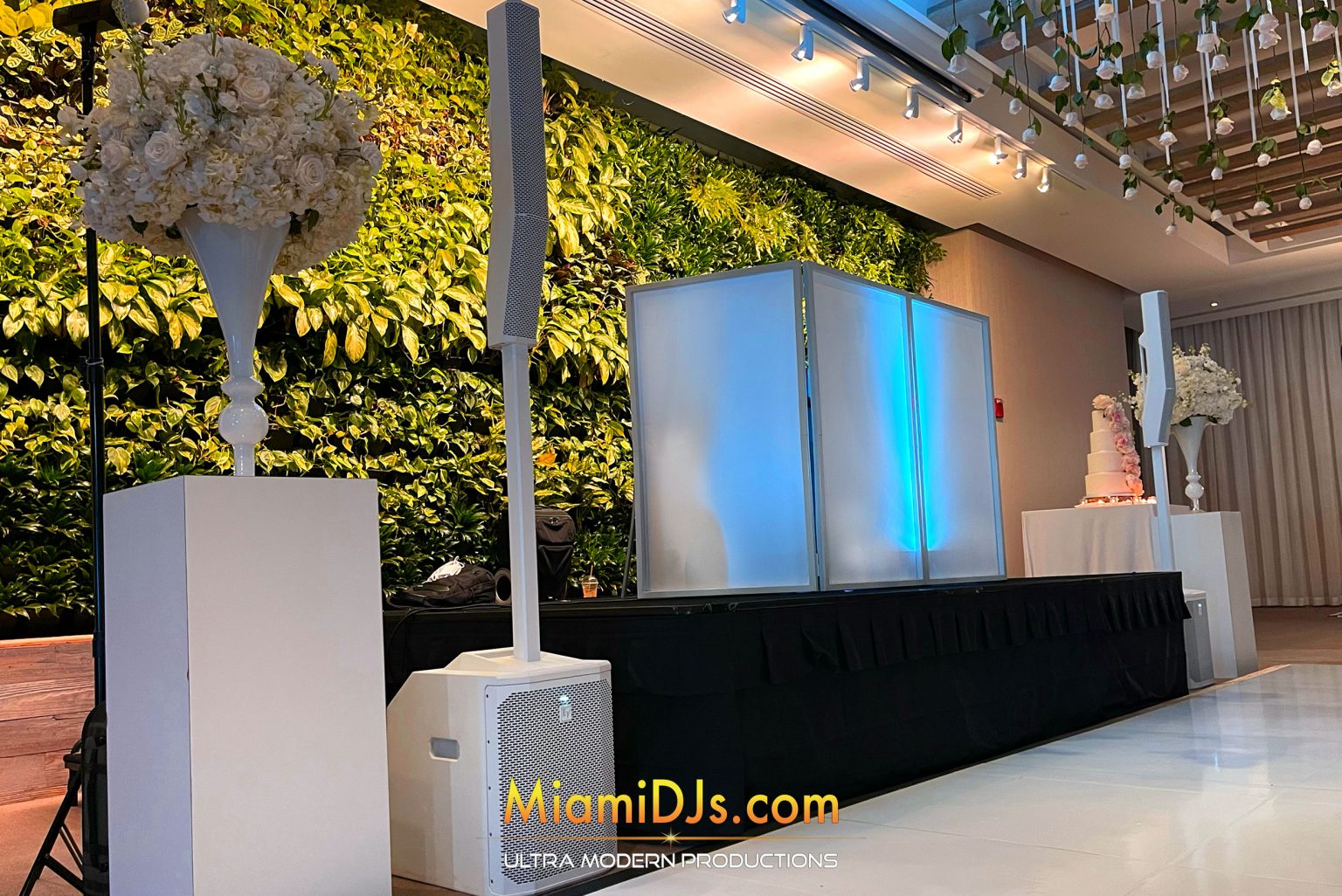 Classic white backlit DJ facade with greenery and white florals