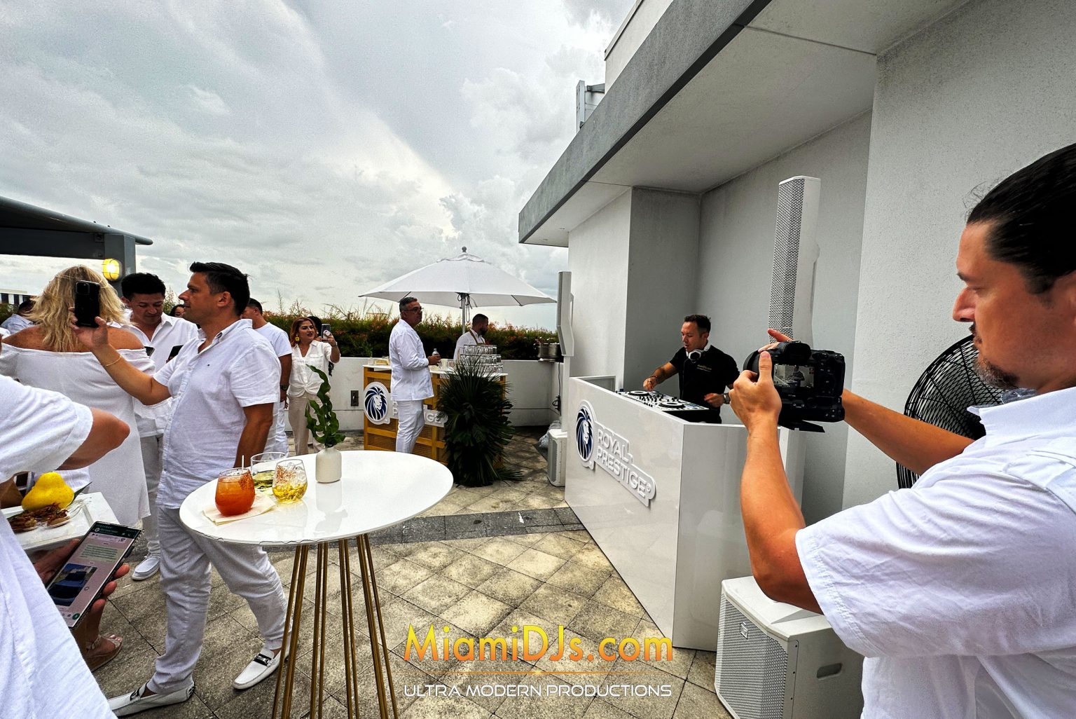 Rooftop corporate party with a DJ booth and white dress code