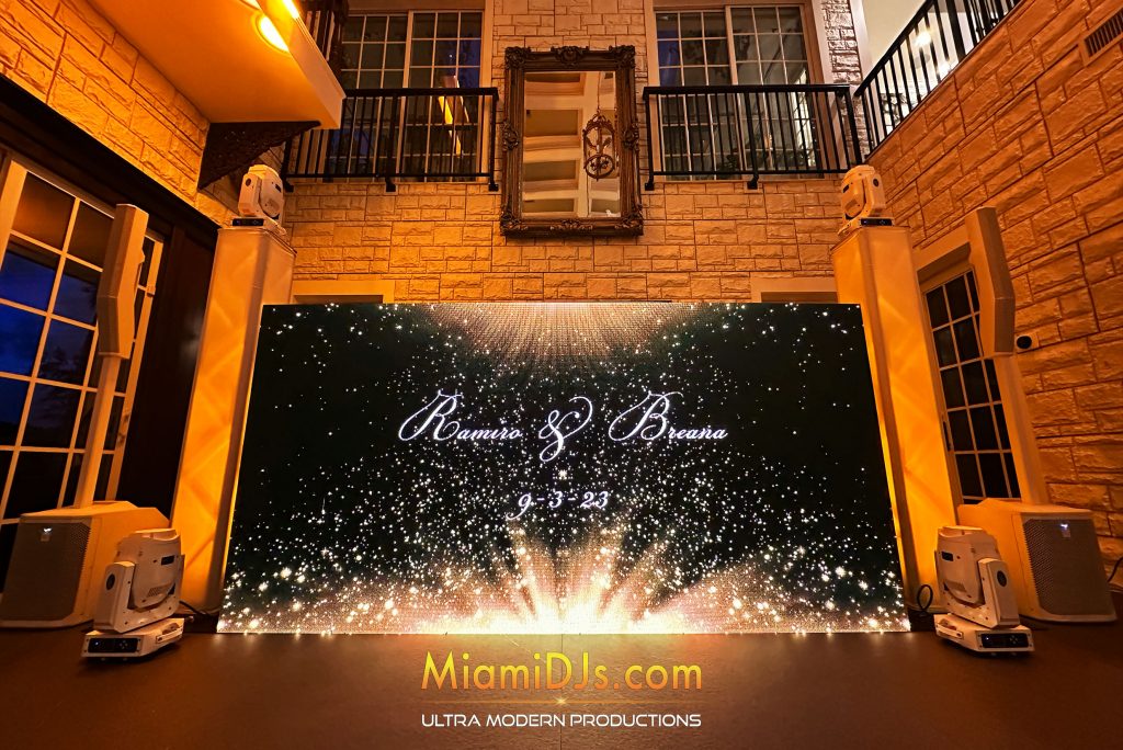 Personalized gold sparkle LED wall between warm uplit columns