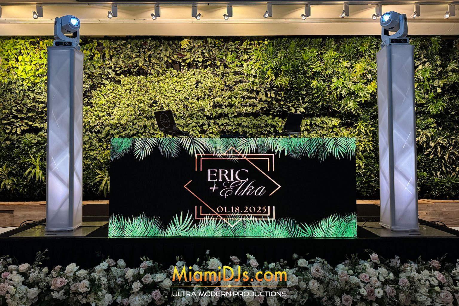 Ultra Modern LED video DJ booth set against a greenery wall with the couple's names