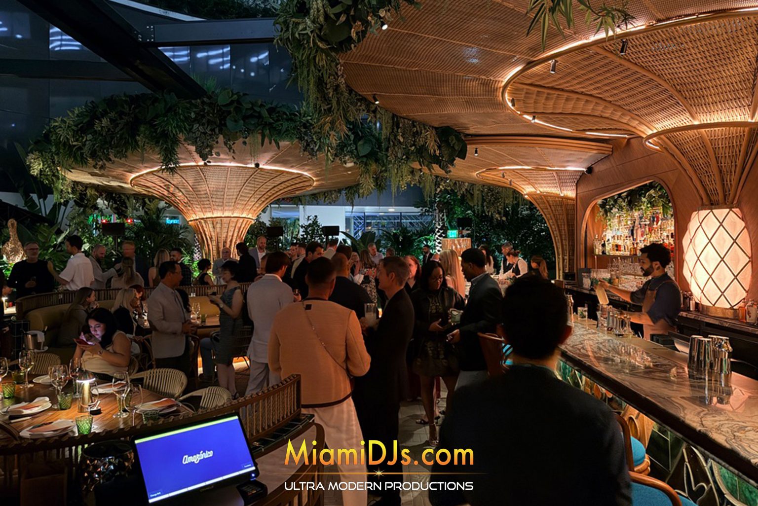 Client appreciation cocktail reception with branded lighting and greenery