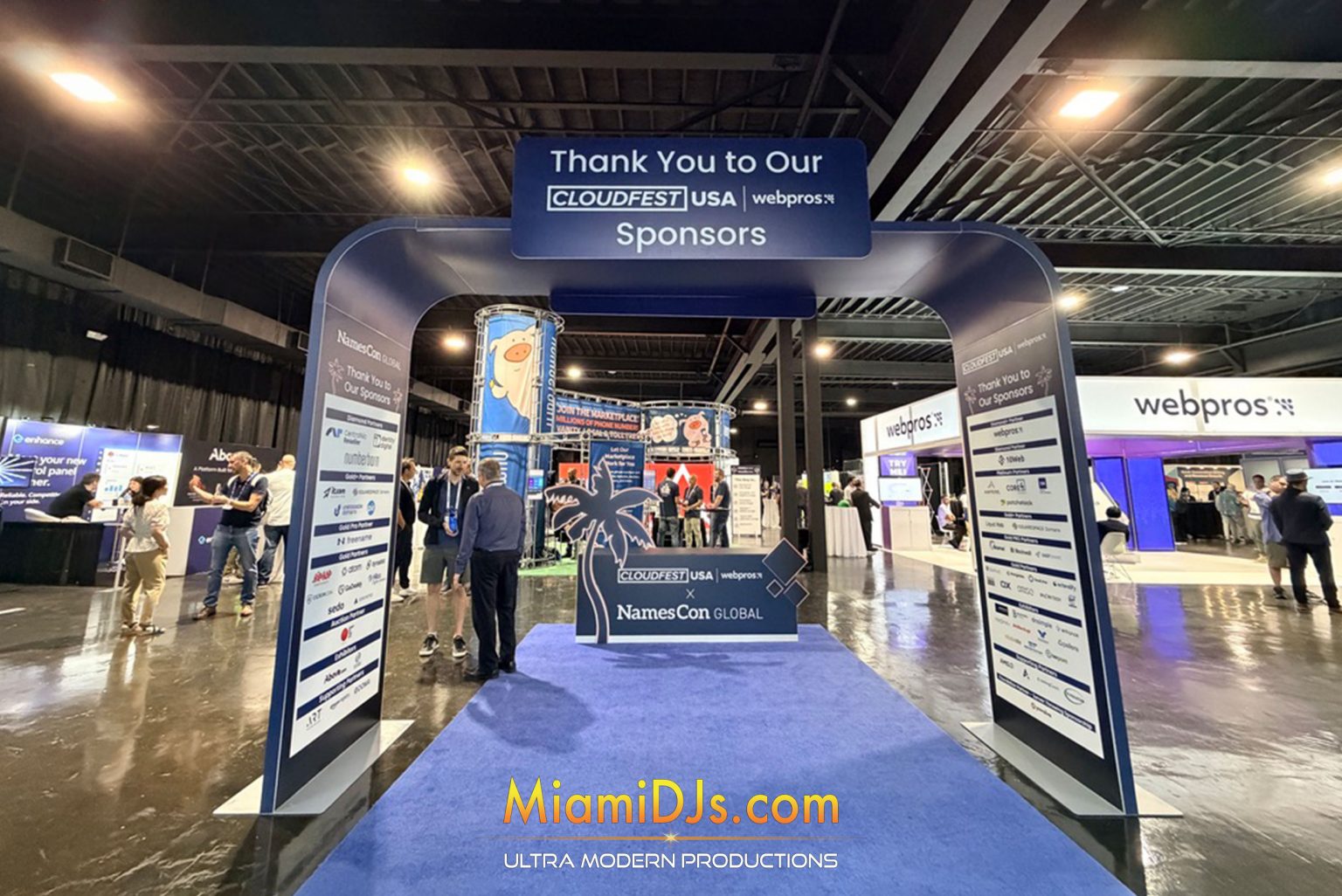 Conference expo hall with branded sponsor arch and staging