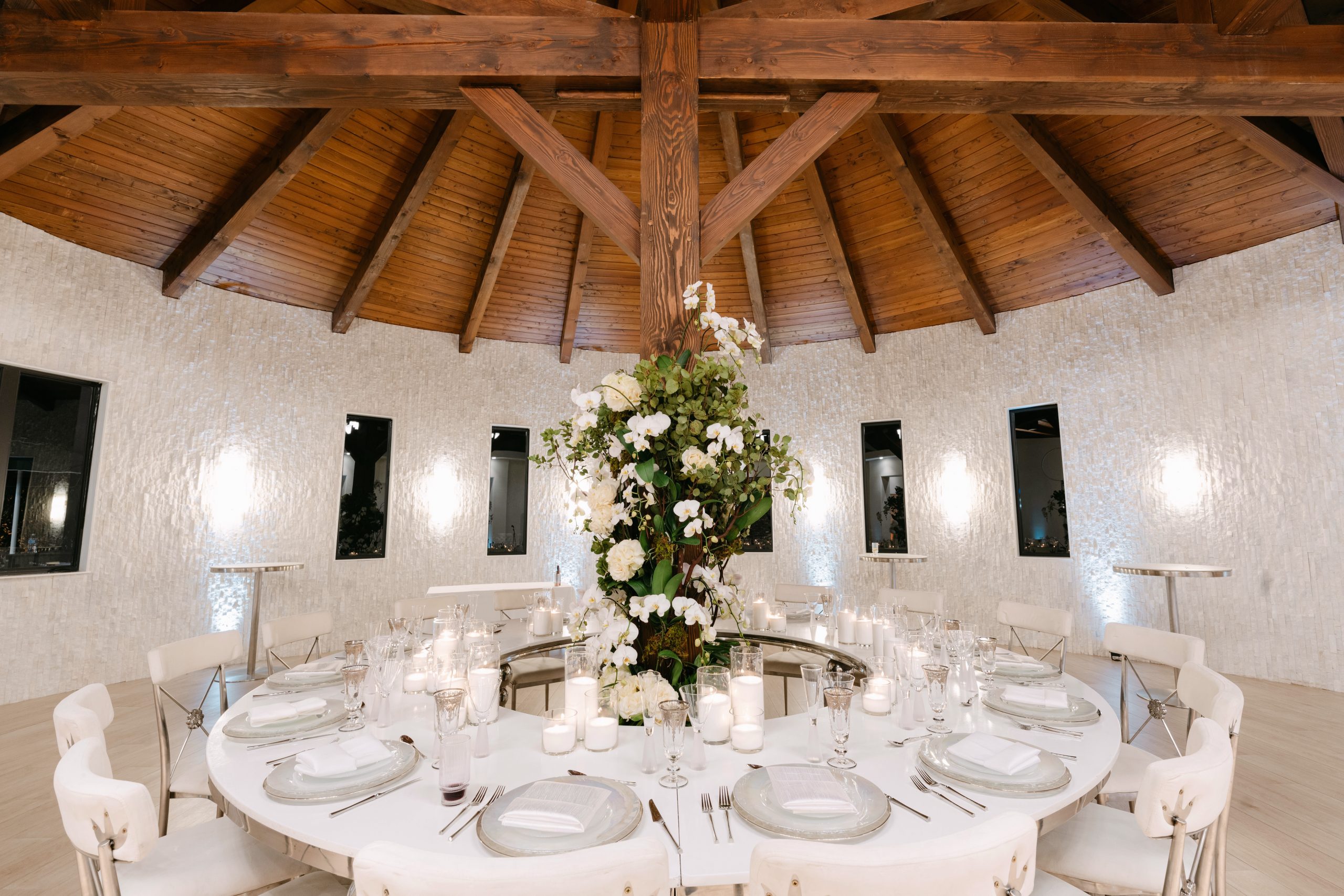 All-white ceremony rotunda with orchid centerpiece