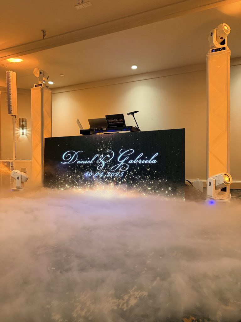 A couple's names in script on the LED wall with a cloud of dry ice rolling across the floor