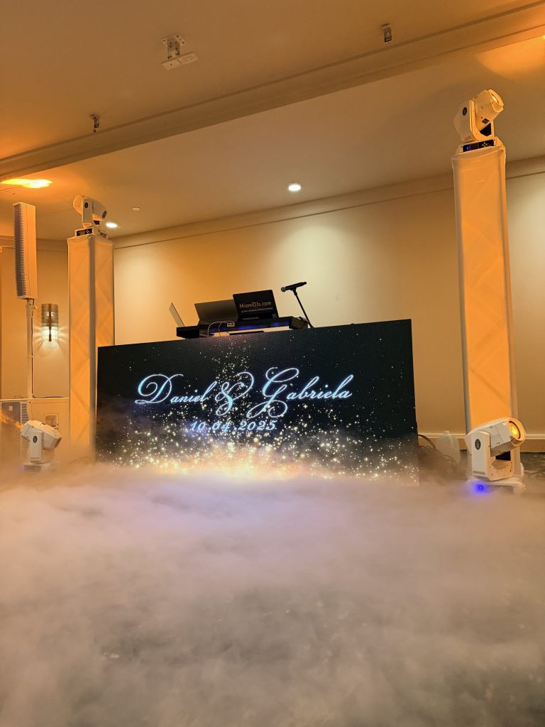 A low cloud of dry ice covering the dance floor beneath the couple's names on the LED wall