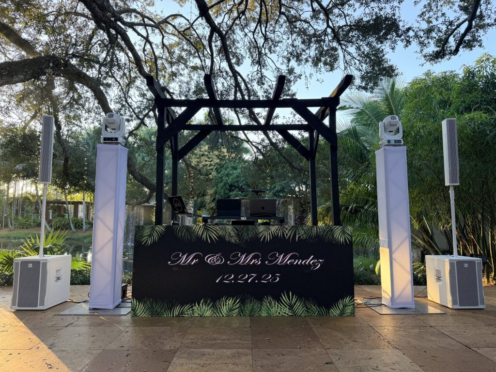 Mr and Mrs Mendez on the LED booth at an outdoor reception under oak trees