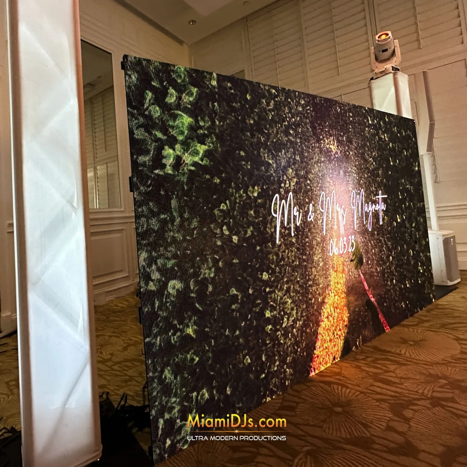 Floral design with names on an LED video wall at a ballroom wedding
