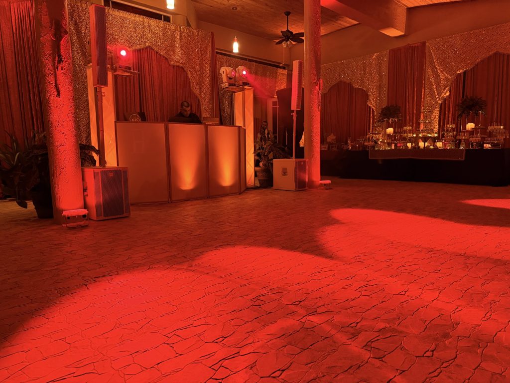 A reception room washed in deep red wireless uplighting