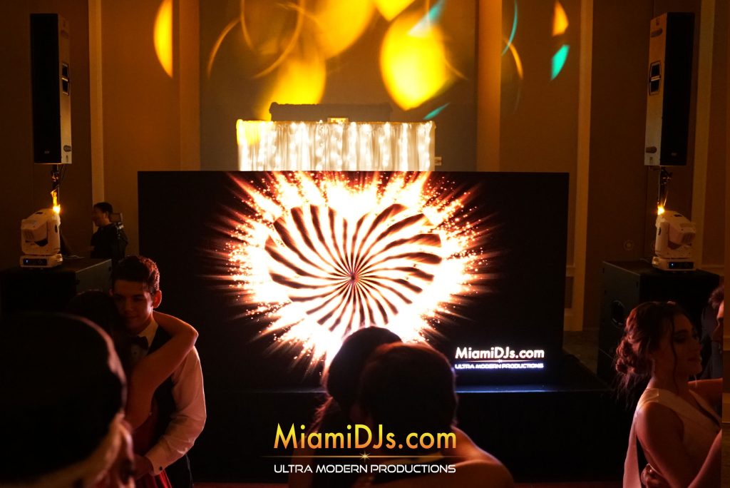 Guests dancing in front of a glowing heart on the LED wall