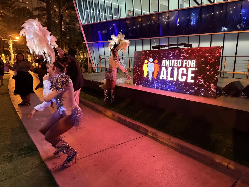 Samba dancers beside an LED wall at the United for ALICE event, Fontainebleau